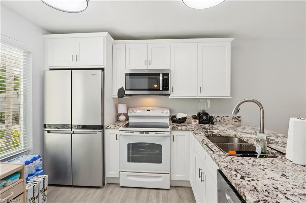 2185 San Marco Road, Unit 3103 Marco Island, FL 34145 - Photo 1 of 22 a kitchen with stainless steel appliances granite countertop a stove a refrigerator and a microwave