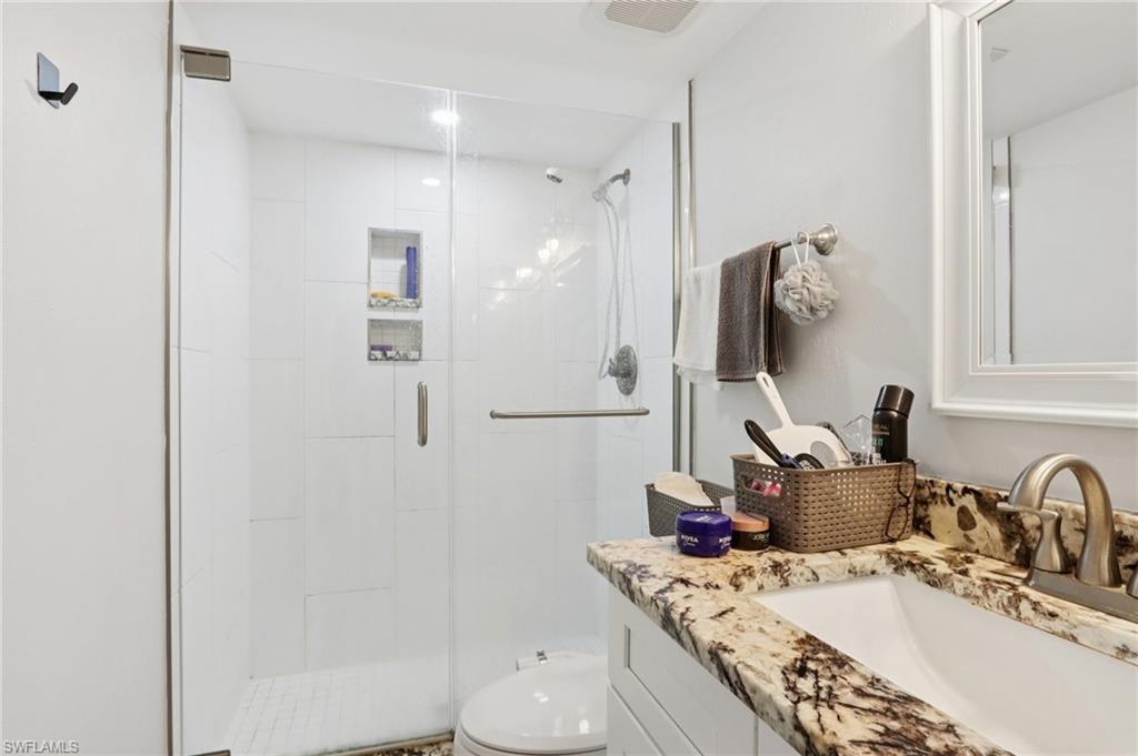 2185 San Marco Road, Unit 3103 Marco Island, FL 34145 - Photo 14 of 22 a bathroom with a granite countertop sink a toilet and shower