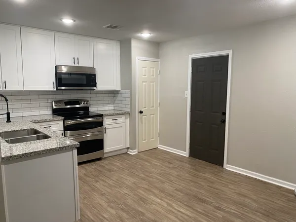 a kitchen with appliances a sink and cabinets