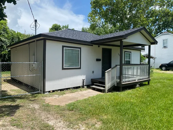 a view of a house with a yard and deck area