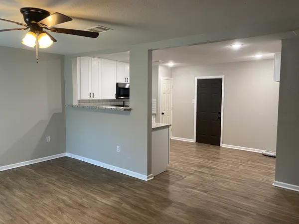 a view of an empty room with wooden floor