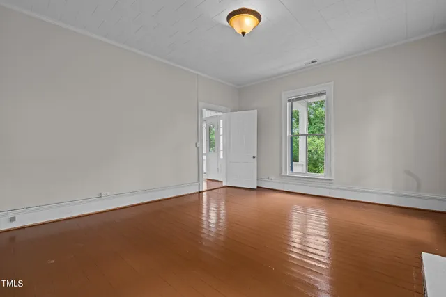 a view of a livingroom with wooden floor and window