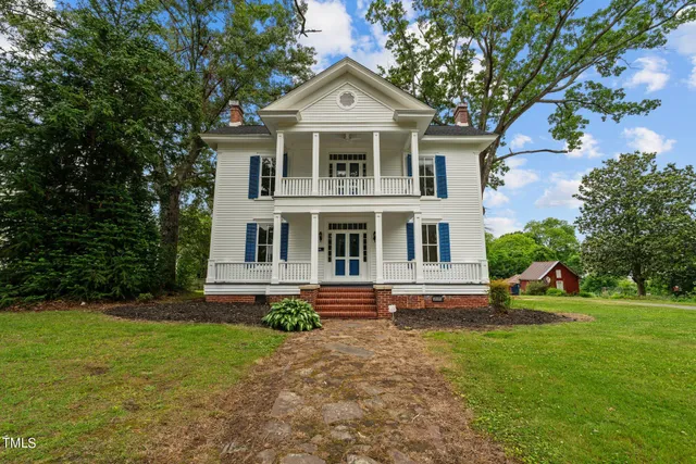 a aerial view of a house with a yard and large trees