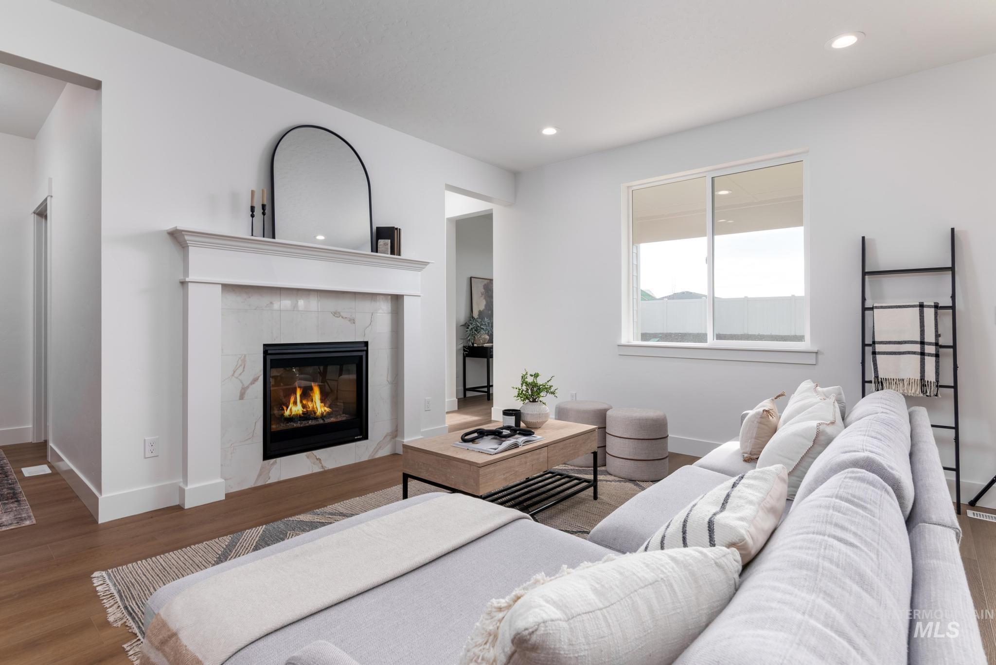 1689 West Paloma Rdg Street Kuna, ID 83634 - Photo 2 of 11 Living area featuring wood finished floors, a fireplace, and recessed lighting