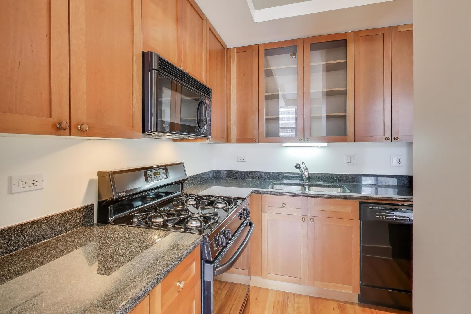 212 West Washington Street, Unit 1708 Chicago, IL 60606 - Photo 10 of 36 a kitchen with granite countertop a sink stove and cabinets