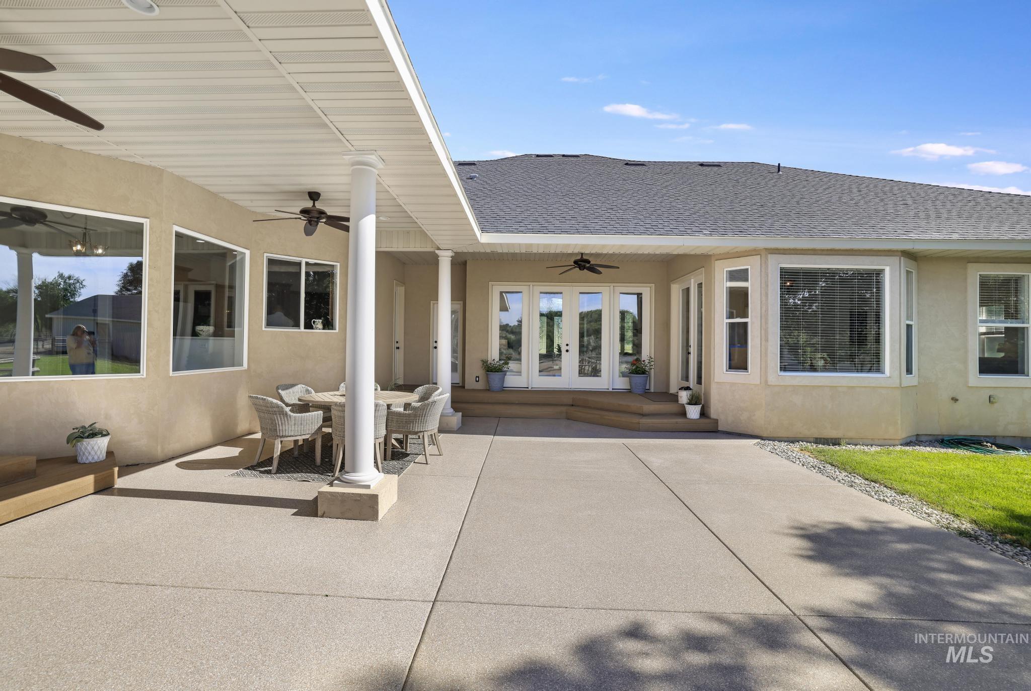 1301 Kanaka Rapids Road Buhl, ID 83316 - Photo 40 of 50 Expansive patio with a covered section, dual ceiling fans, multiple windows, double glass doors, and a bay window feature