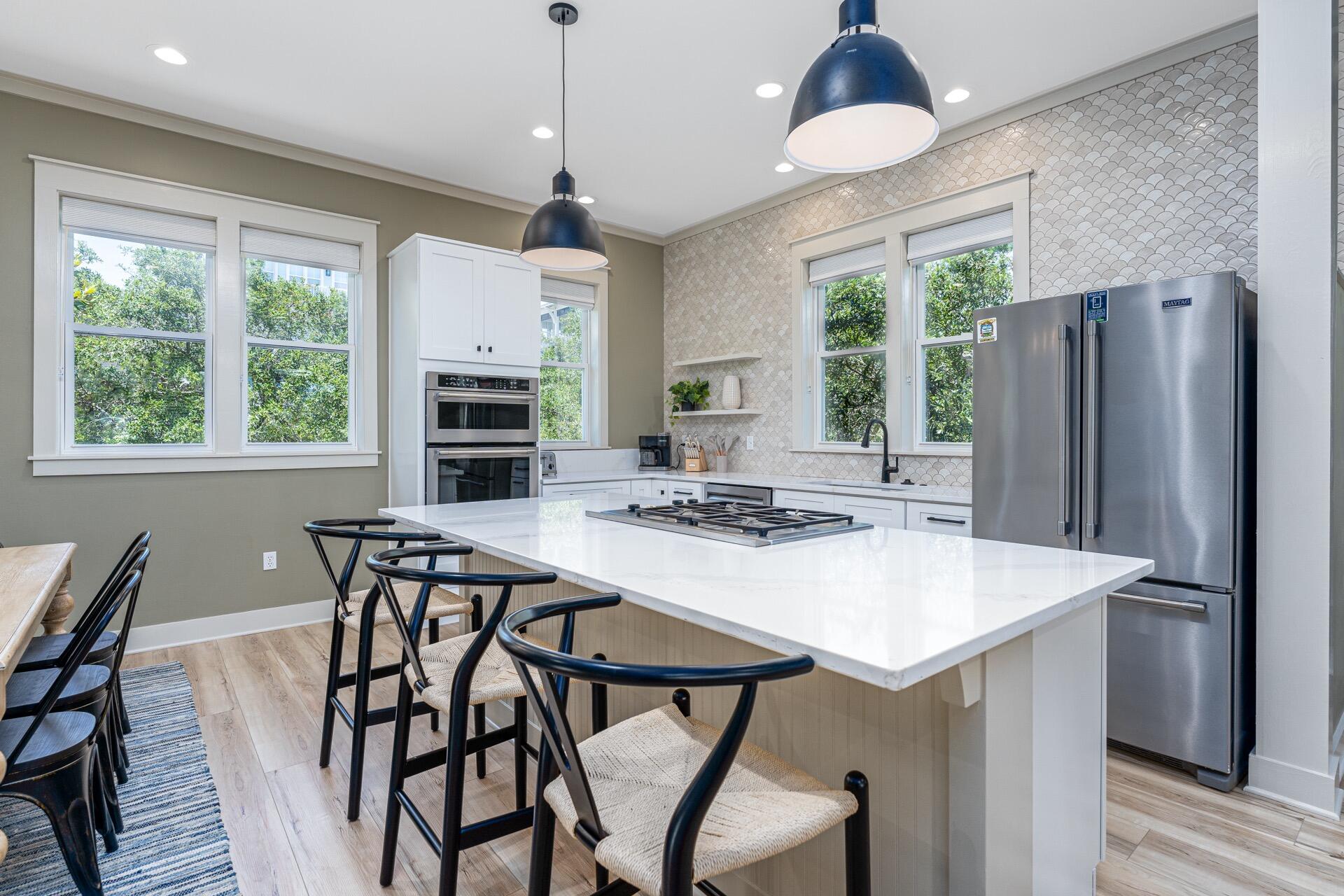 186 Old Beach Road Santa Rosa Beach, FL 32459 - Photo 6 of 21 a kitchen with stainless steel appliances a dining table and chairs
