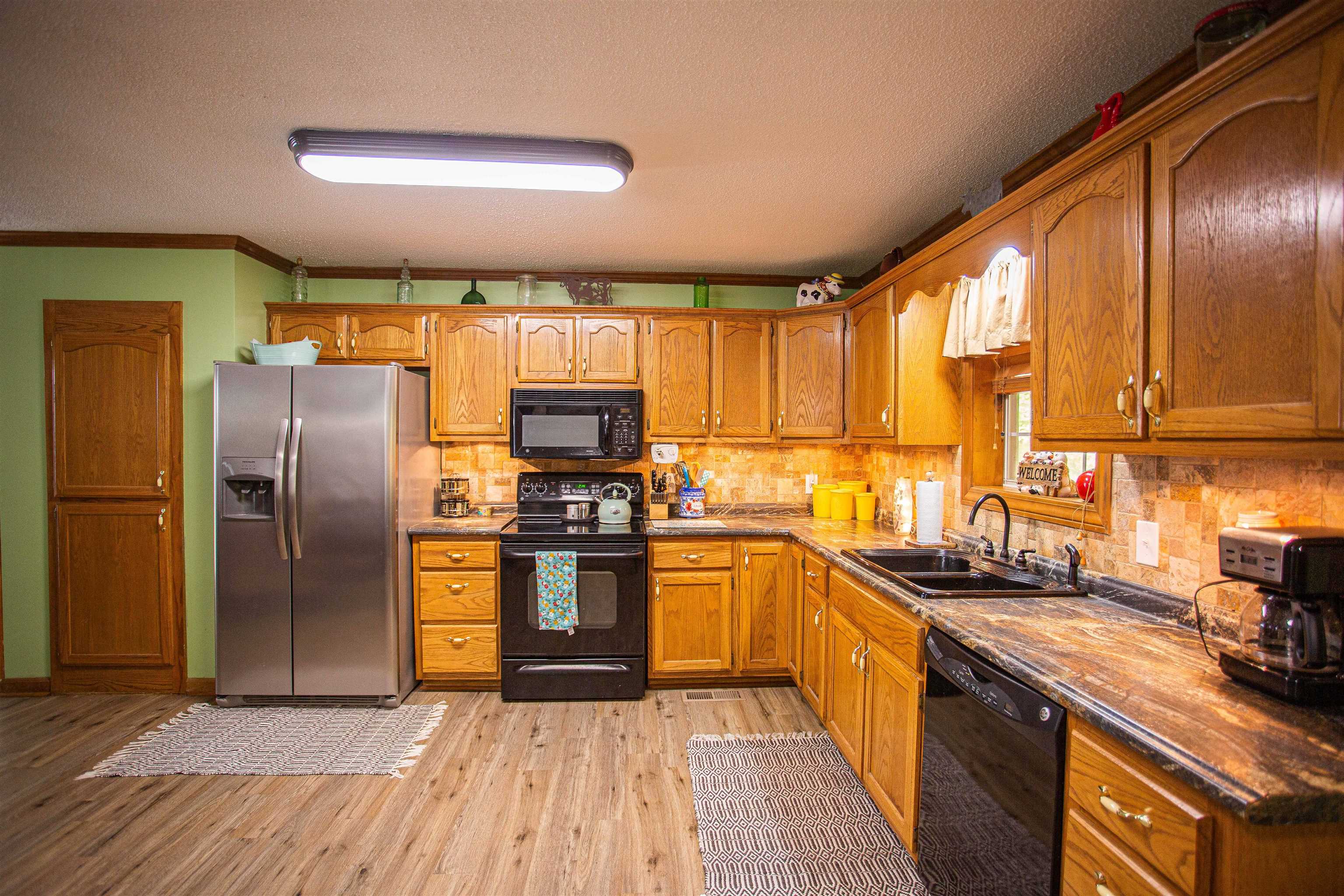 90 Aubrey Lane Ripley, TN 38063 - Photo 4 of 25 a kitchen with stainless steel appliances granite countertop a refrigerator a sink dishwasher a stove with wooden cabinets and floor