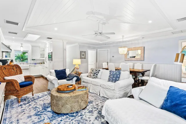 a large white kitchen with stainless steel appliances granite countertop a lot of counter space and wooden floors