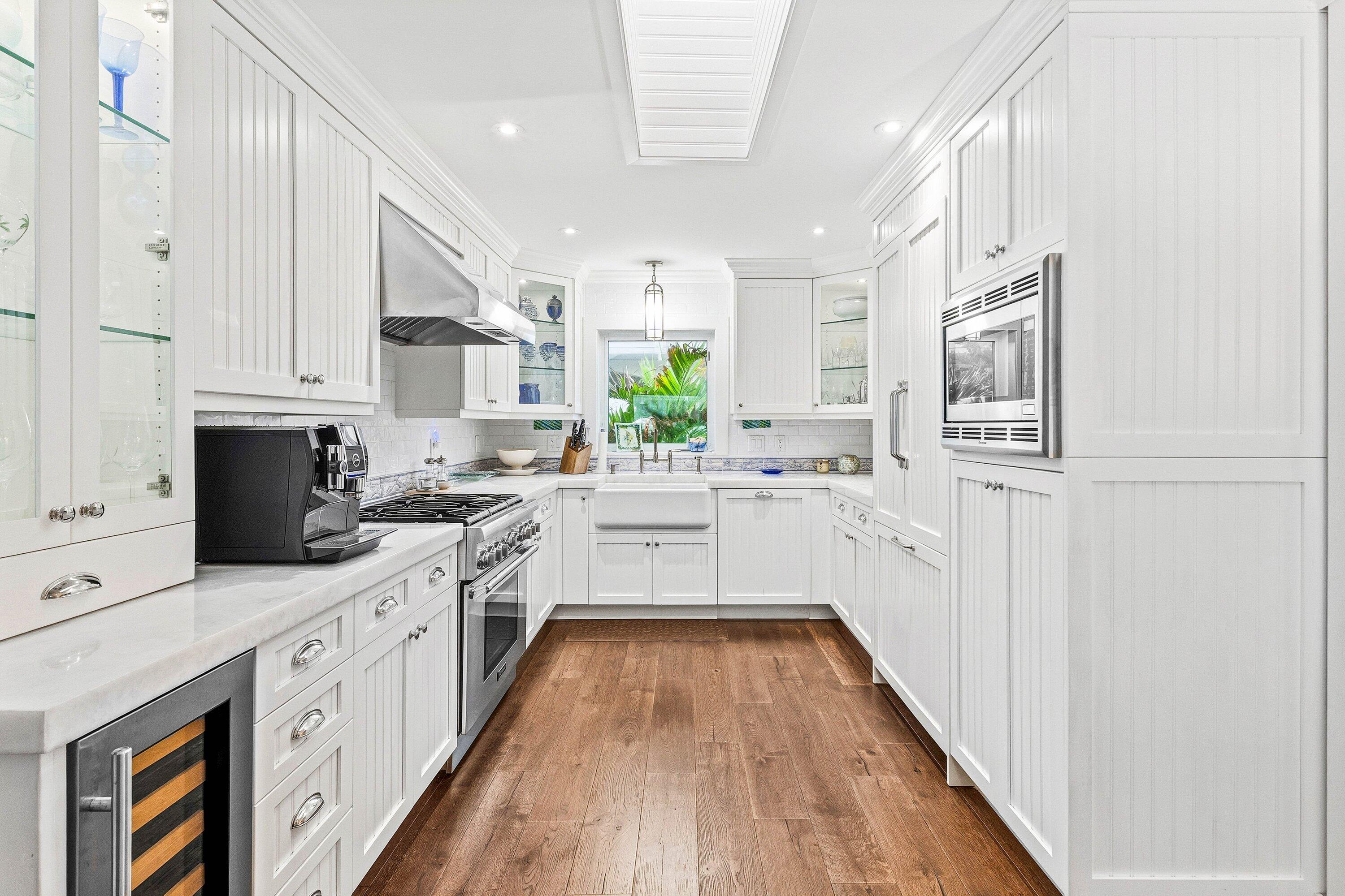 3421 South Ocean Boulevard, Unit 1 Highland Beach, FL 33487 - Photo 13 of 42 a large white kitchen with stainless steel appliances granite countertop a lot of counter space and wooden floors