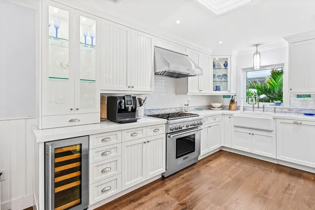 a open kitchen with stainless steel appliances granite countertop a stove and a wooden floors