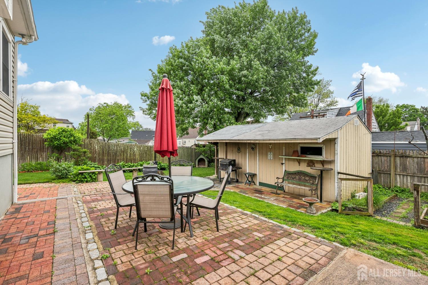 153 East Hill Road Colonia, NJ 07067 - Photo 26 of 40 a view of a patio with a table and chairs under an umbrella