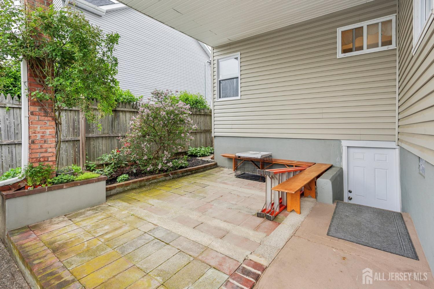 153 East Hill Road Colonia, NJ 07067 - Photo 32 of 40 a backyard of a house with potted plants and a bench