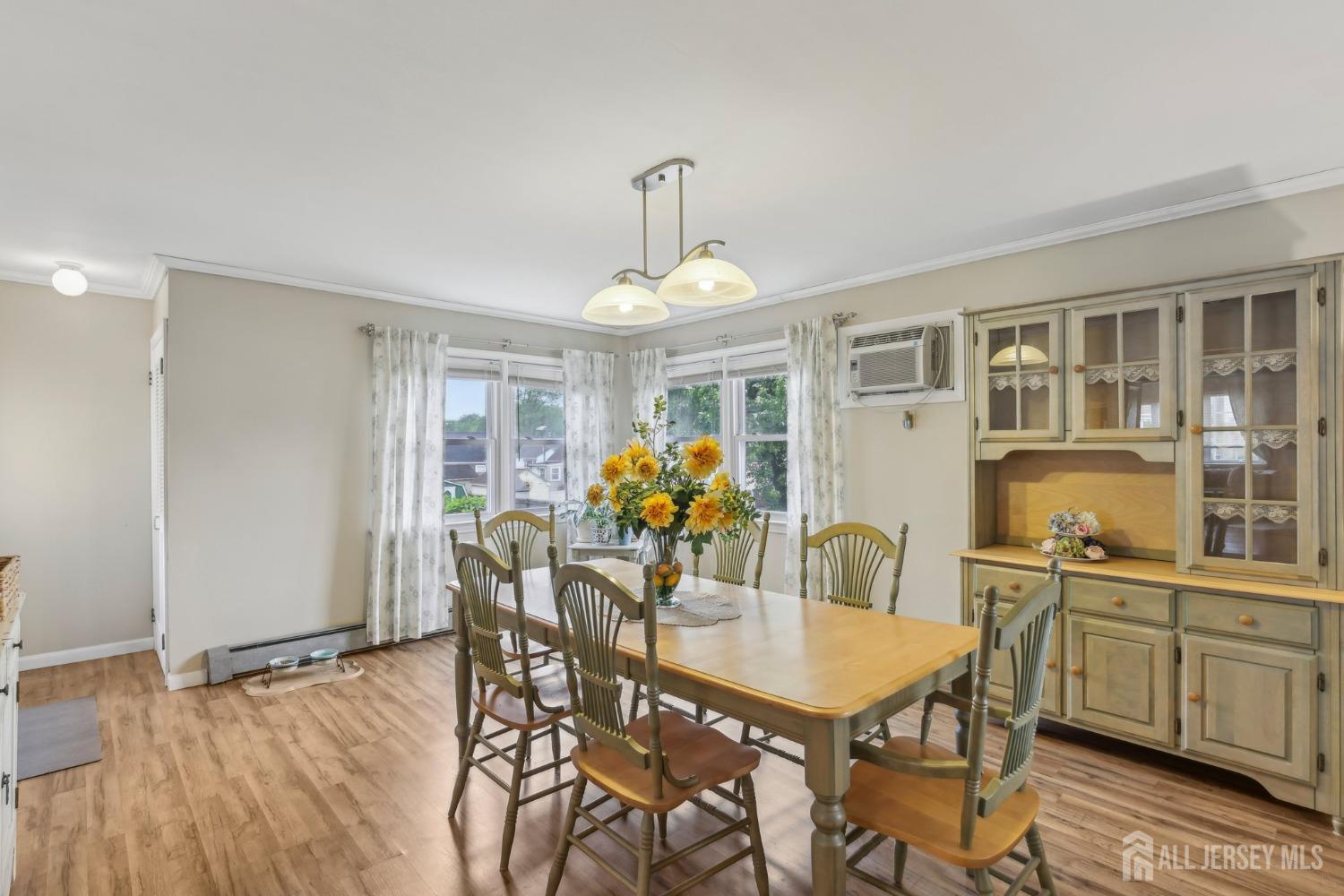 153 East Hill Road Colonia, NJ 07067 - Photo 7 of 40 a dining room with furniture a chandelier and wooden floor