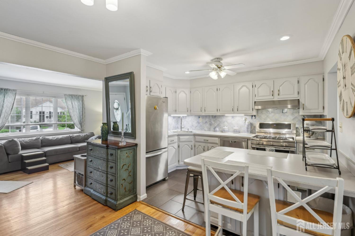 153 East Hill Road Colonia, NJ 07067 - Photo 9 of 40 a kitchen with stainless steel appliances kitchen island granite countertop a stove a refrigerator a dining table and chairs with wooden floor