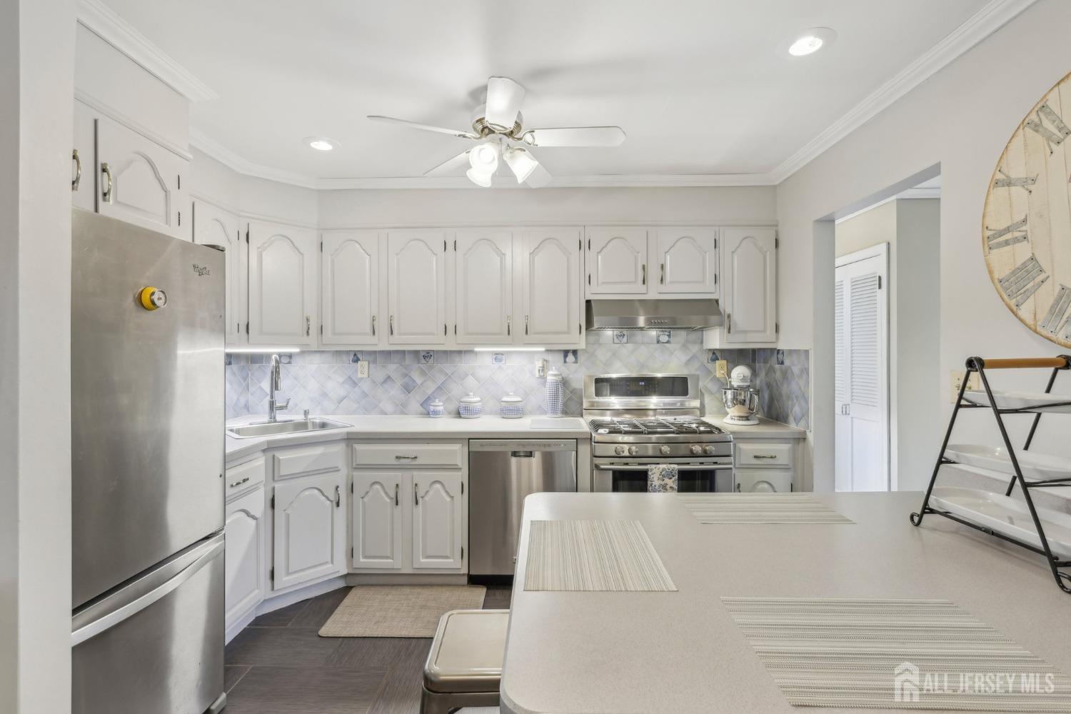 153 East Hill Road Colonia, NJ 07067 - Photo 10 of 40 a kitchen with kitchen island white cabinets and stainless steel appliances