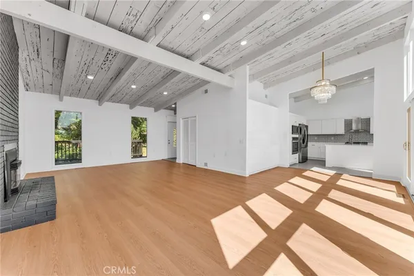 a living room with stainless steel appliances furniture and a kitchen view