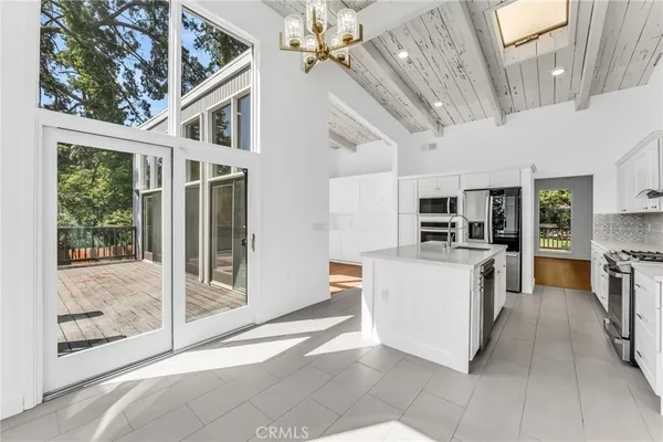 a view of an empty room with wooden floor fireplace and a window