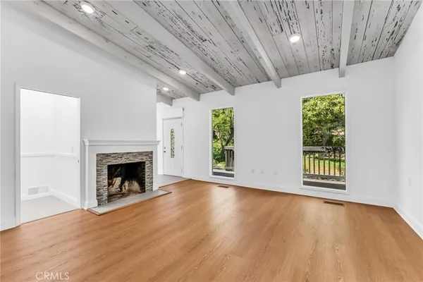 a view of an empty room with a fireplace and a window