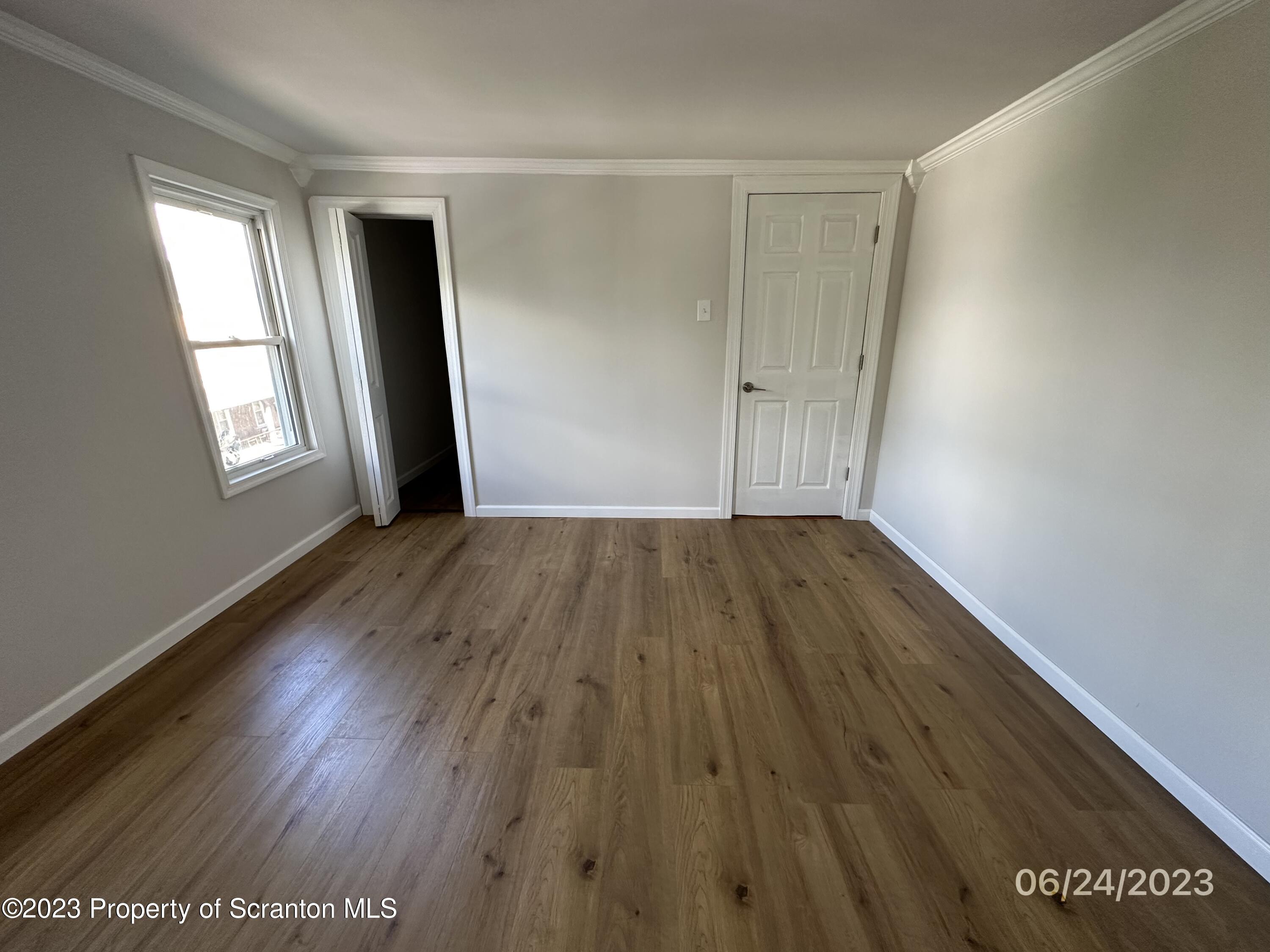 811 Eynon Street Scranton, PA 18504 - Photo 13 of 16 an empty room with wooden floor and windows