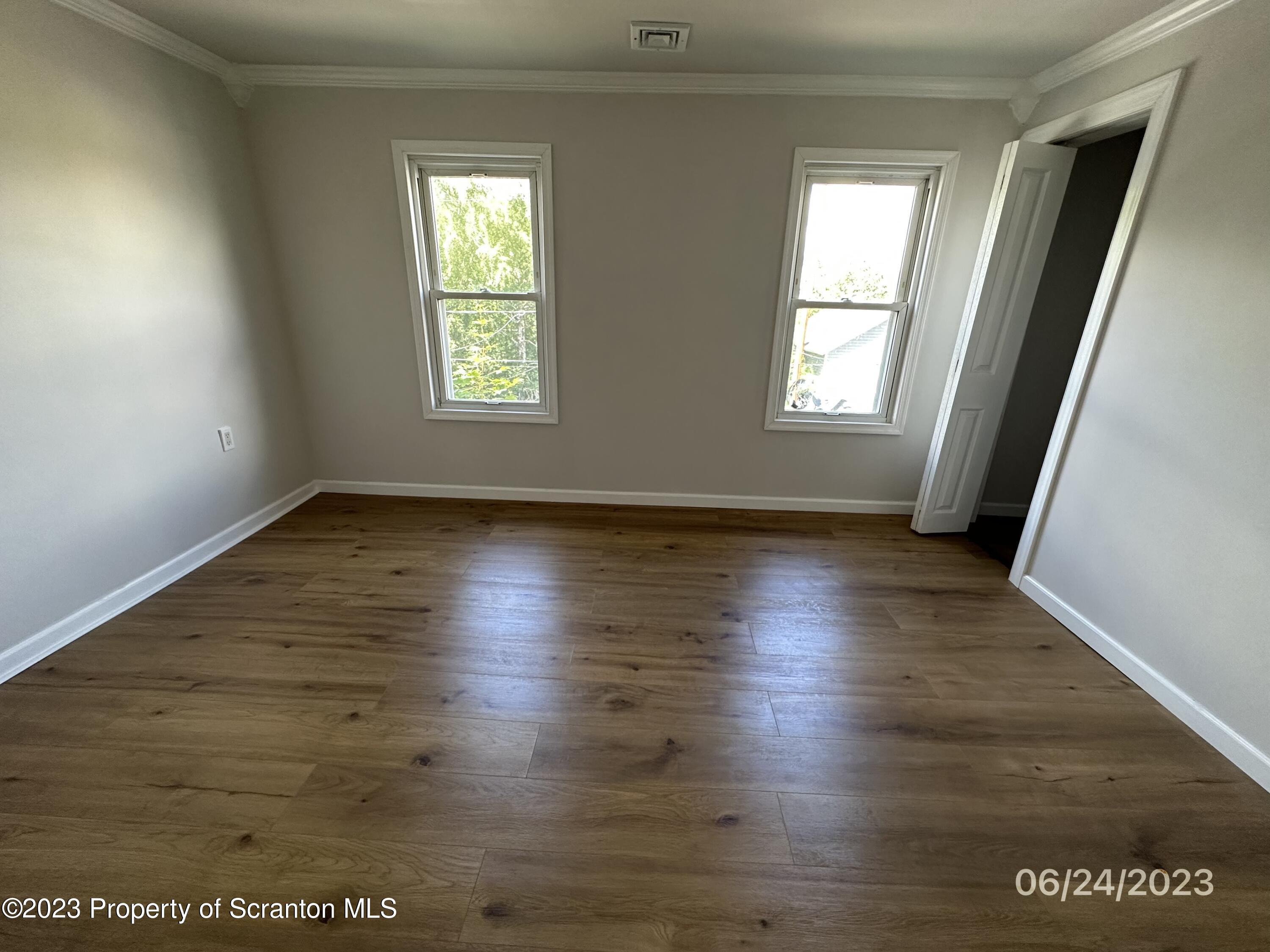 811 Eynon Street Scranton, PA 18504 - Photo 14 of 16 an empty room with wooden floor and windows