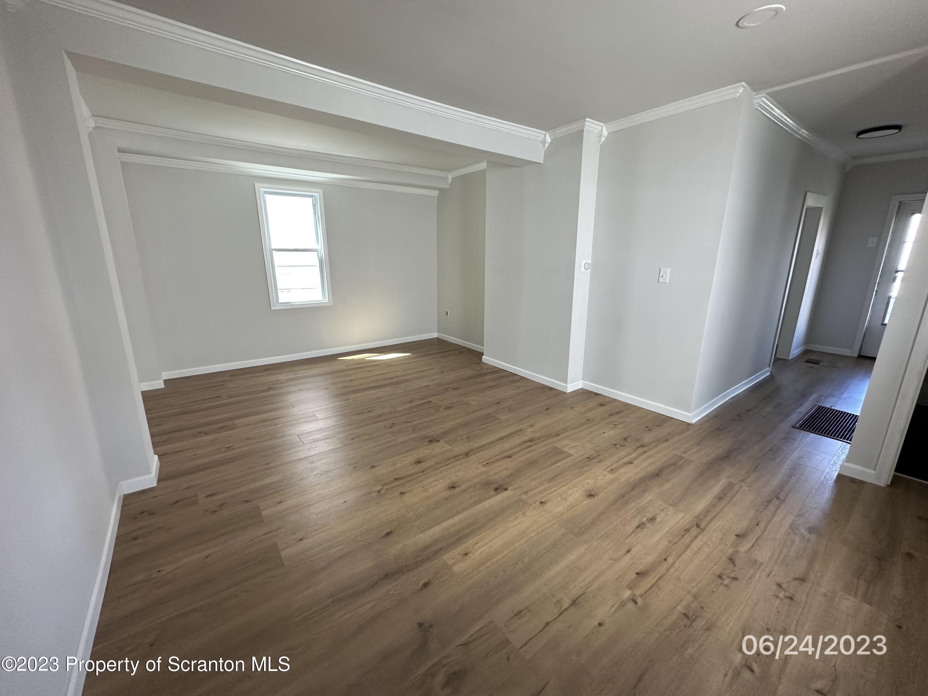 811 Eynon Street Scranton, PA 18504 - Photo 4 of 16 an empty room with wooden floor and windows