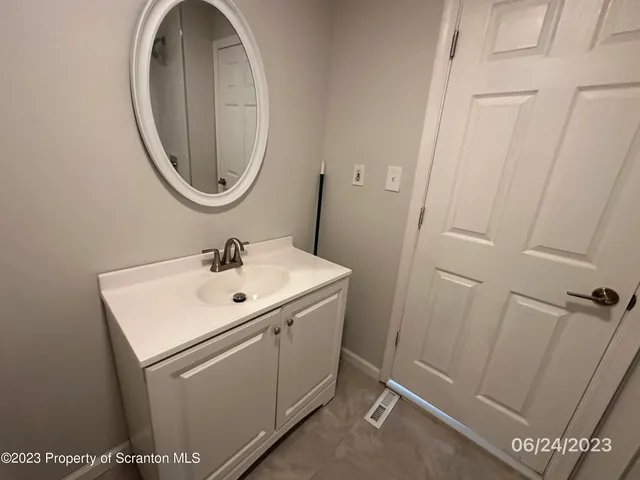a white sink sitting under a mirror