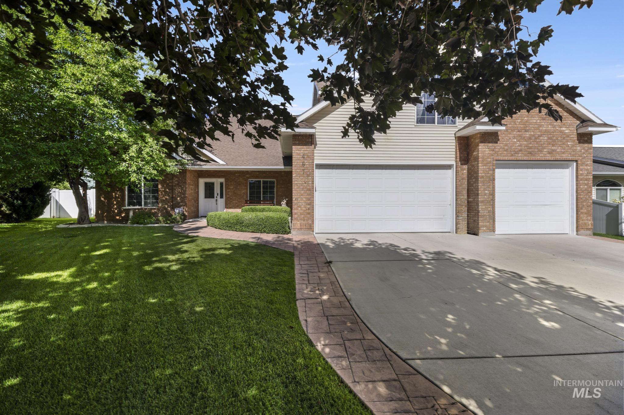 467 Wildrose Loop Twin Falls, ID 83301 - Photo 3 of 46 Brick and siding exterior featuring a multi-car garage, a concrete driveway, and a paved walkway