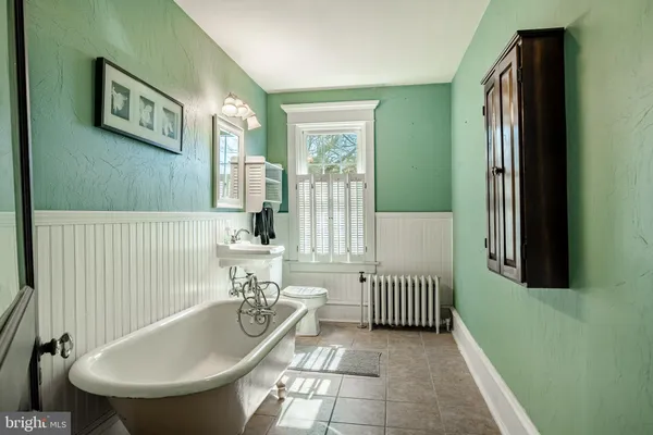 a bathroom with a tub a sink and a window