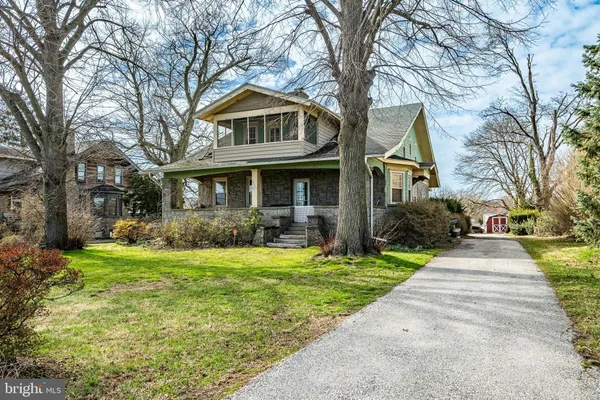 a front view of a house with a yard and trees