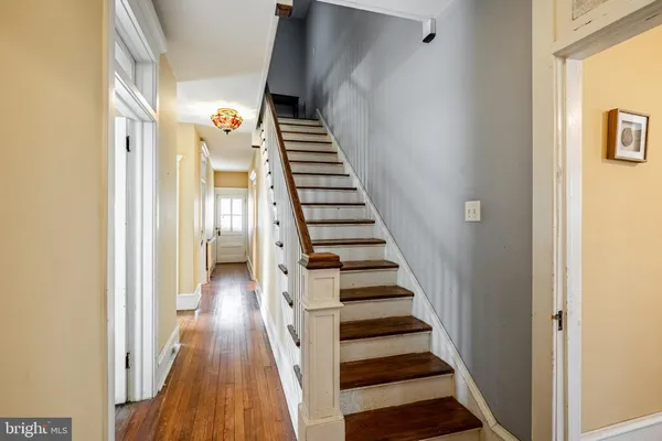 a view of a hallway with wooden floor and entryway