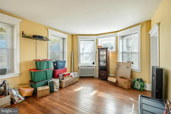 a living room with furniture floor to ceiling window and wooden floor