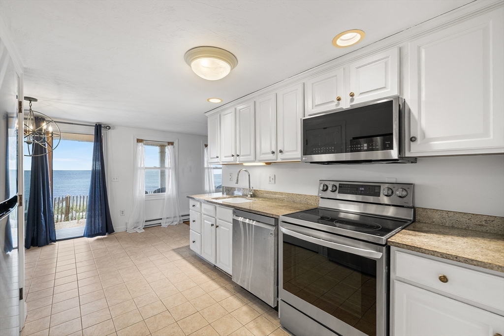 544 Shore Road, Unit 3 Truro, MA 02666 - Photo 16 of 30 a kitchen with stainless steel appliances granite countertop a stove a sink and a microwave