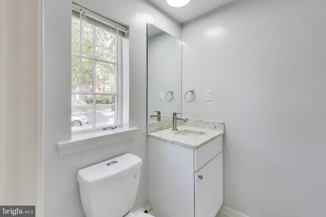 a spacious bathroom with a toilet sink and mirror