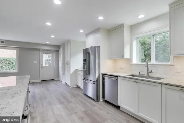 a kitchen with stainless steel appliances granite countertop a refrigerator and a sink