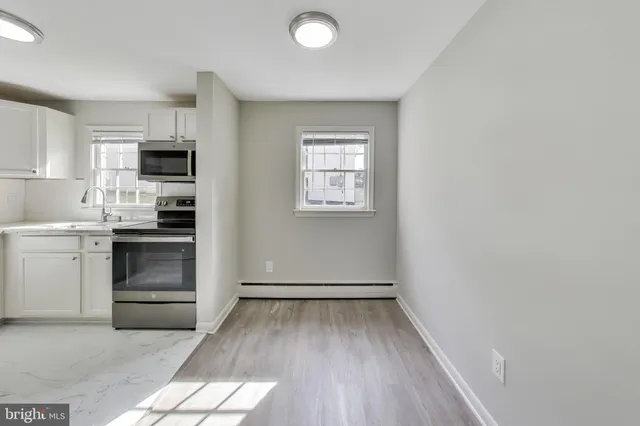 a kitchen with a refrigerator and a stove top oven