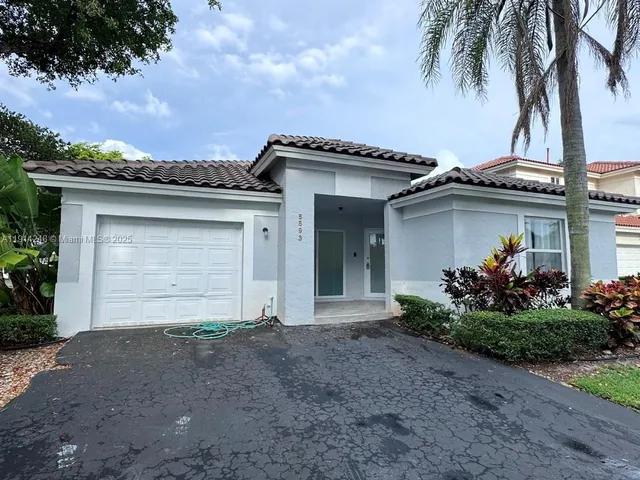 front view of a house with a potted plant and a garage