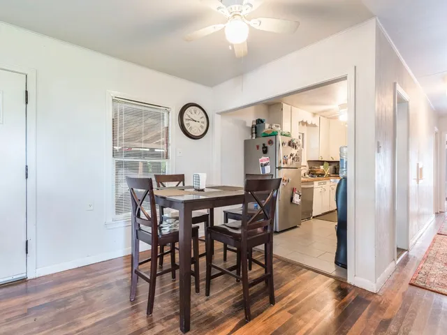 a view of a dining room and livingroom with furniture wooden floor a chandelier