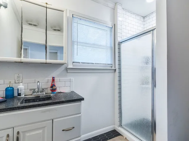 a kitchen with stainless steel appliances granite countertop white cabinets and a potted plant