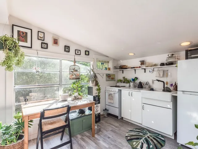 a kitchen with white cabinets and window
