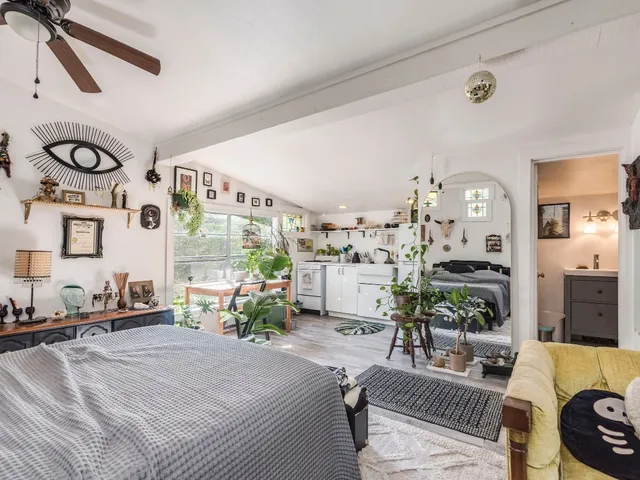 a bedroom with furniture and a large window
