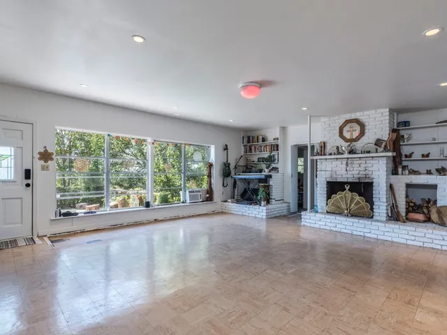 a view of an empty room with a fireplace and a large window