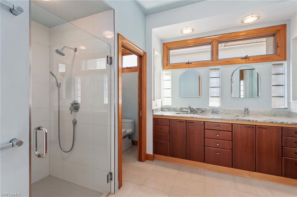 550 Starboard Drive Naples, FL 34103 - Photo 12 of 28 a bathroom with a granite countertop sink mirror and a shower