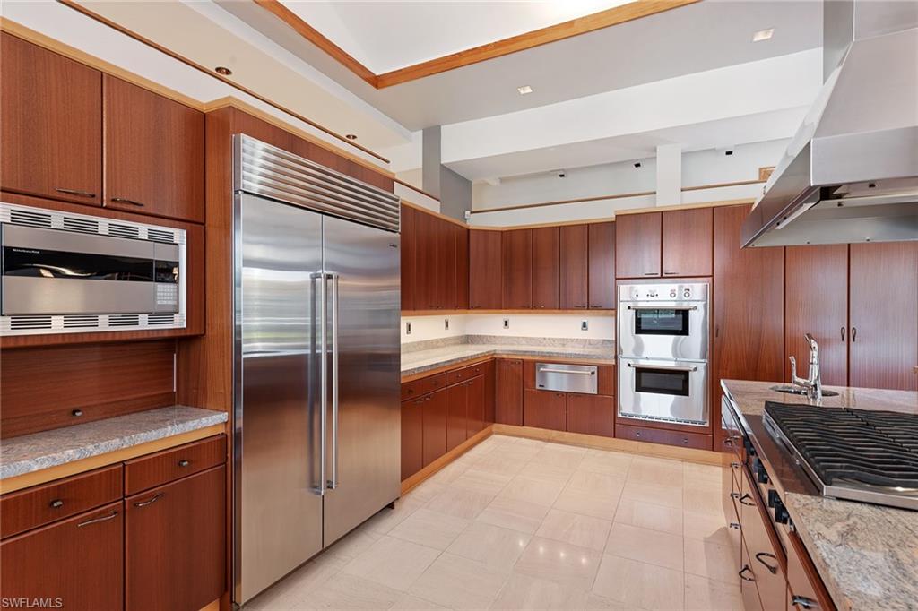 550 Starboard Drive Naples, FL 34103 - Photo 2 of 28 a kitchen with granite countertop stainless steel appliances and wooden cabinets