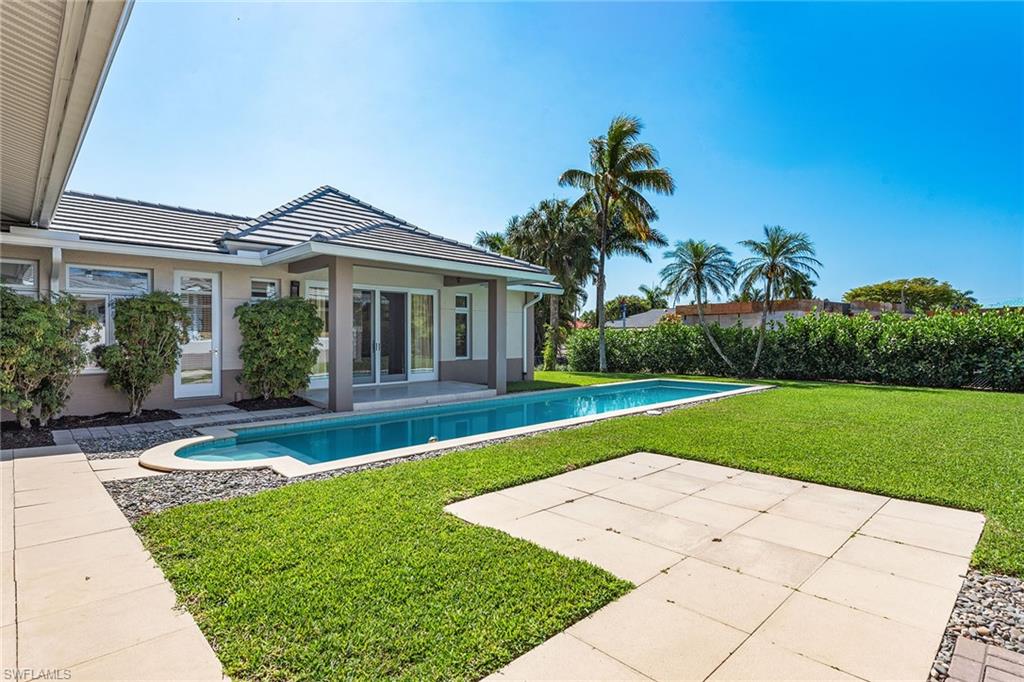 550 Starboard Drive Naples, FL 34103 - Photo 27 of 28 a front view of a house with garden