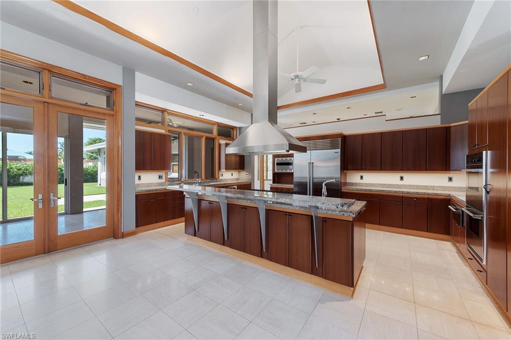 550 Starboard Drive Naples, FL 34103 - Photo 3 of 28 a large kitchen with stainless steel appliances wooden cabinets and a stove