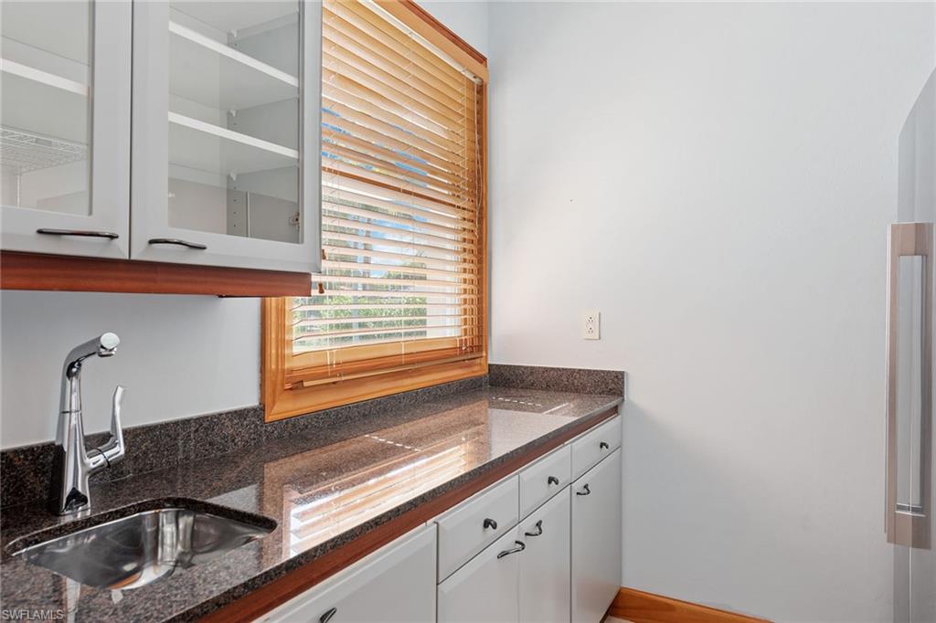 550 Starboard Drive Naples, FL 34103 - Photo 9 of 28 a kitchen with granite countertop white cabinets and a sink