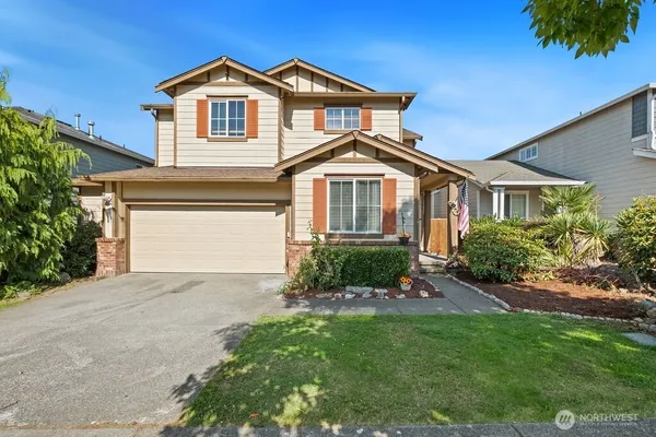 a front view of a house with a yard and garage