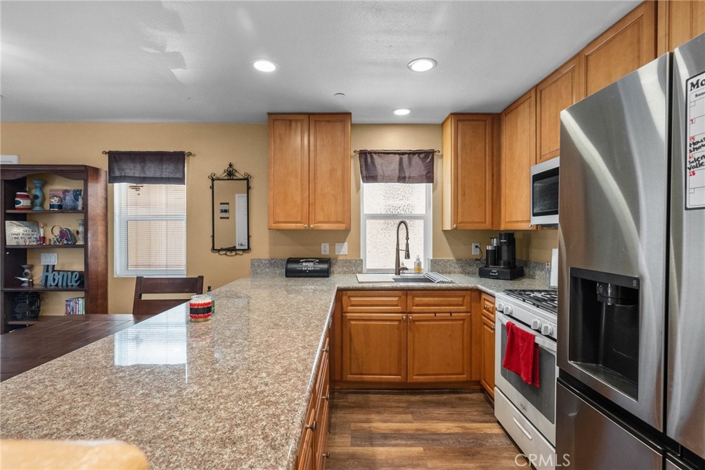 26135 Gravett Place Saugus, CA 91350 - Photo 11 of 31 a kitchen with stainless steel appliances granite countertop a refrigerator a stove and a sink