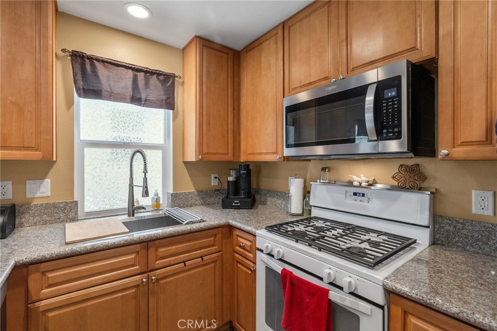 26135 Gravett Place Saugus, CA 91350 - Photo 12 of 31 a kitchen with stainless steel appliances granite countertop a stove a microwave and sink